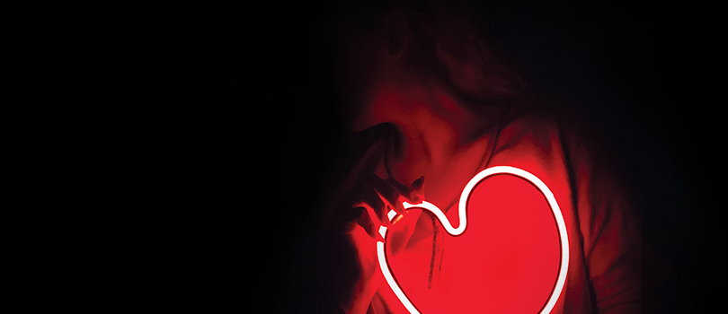 Femme qui tient une forme de coeur fluorescent